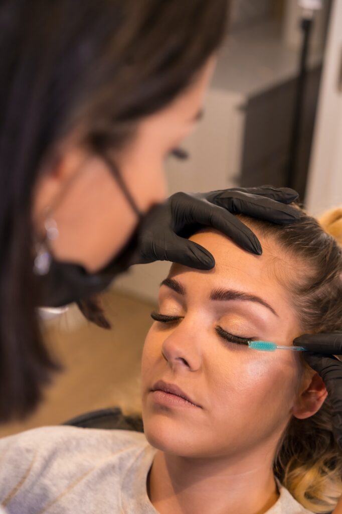 Applying mascara to eyelashes of a woman in a salon